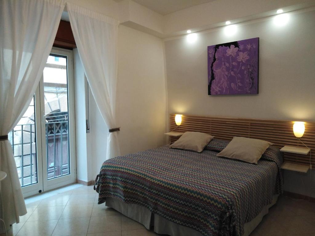 ナポリにあるCasa Nel Cuore Di Napoli centro storicoのベッドルーム1室(紫色の絵画が壁に描かれたベッド1台付)
