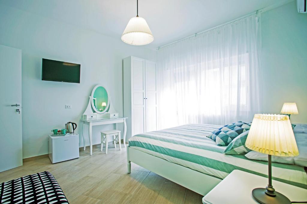 a bedroom with a bed and a table with a lamp at B&B Sapore di Mare al Corso in Gaeta