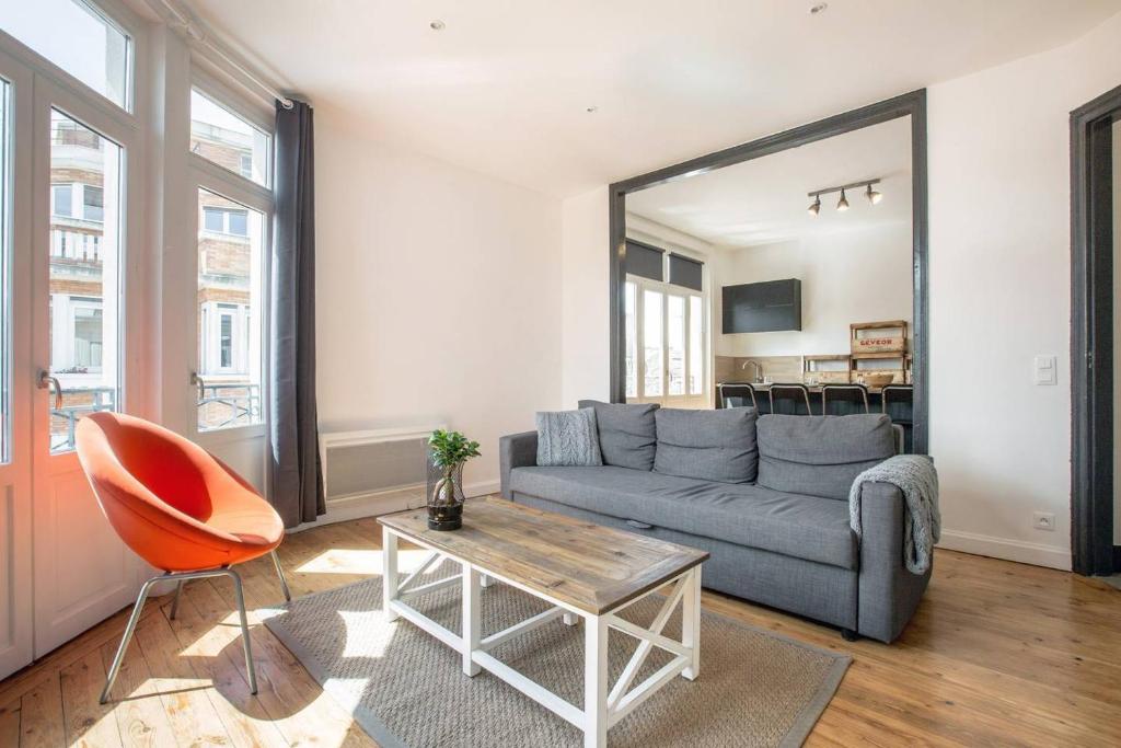 sala de estar con sofá, mesa y espejo en Grand appart 85m2 de standing, hyper centre/gare, en Lille