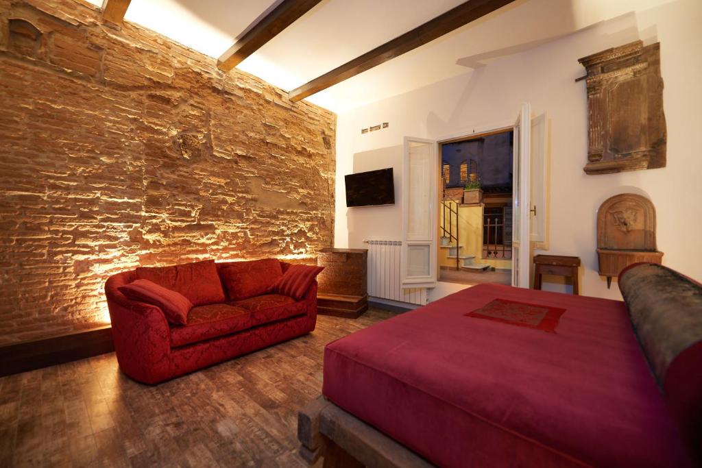 - une chambre avec un lit rouge et un canapé dans l'établissement Luxury Penthouse with Terrace, à Florence
