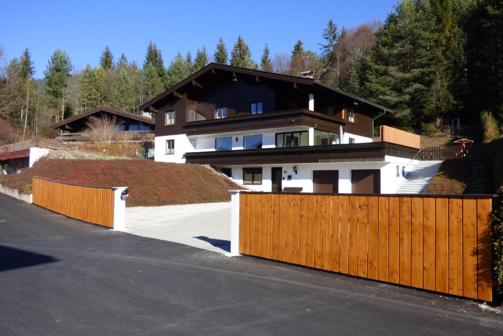 een huis met een houten hek voor een oprit bij Haus Alois Nußbaumer jun. in Saalfelden am Steinernen Meer