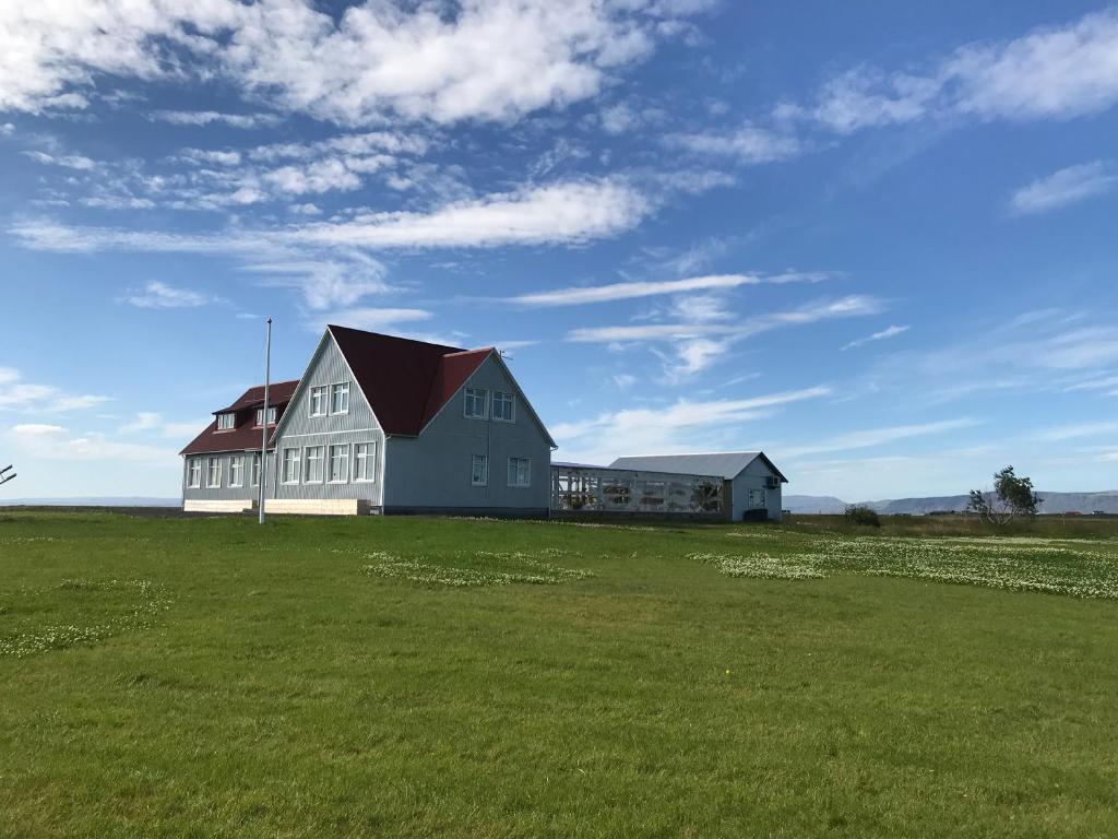 a large house in a field with a green field at The Old School House - Gaulverjaskoli in Selfoss