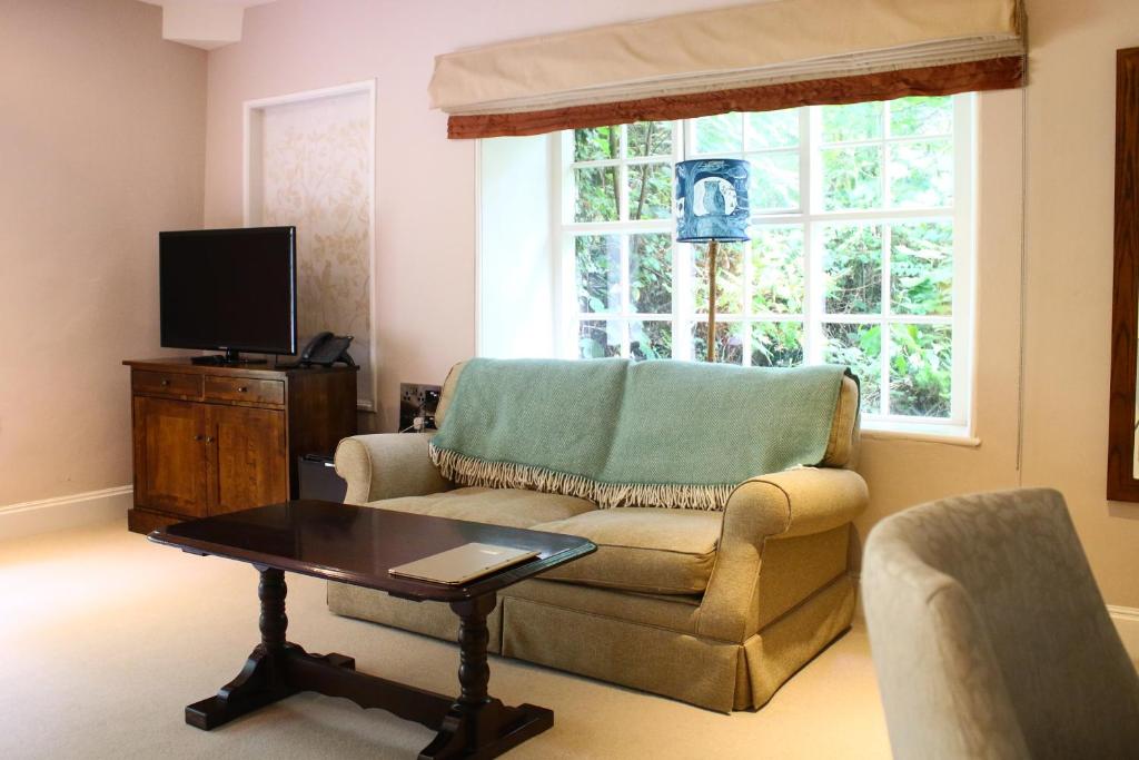ein Wohnzimmer mit Couch und Fernseher in der Unterkunft Plas Nanteos Mansion in Aberystwyth
