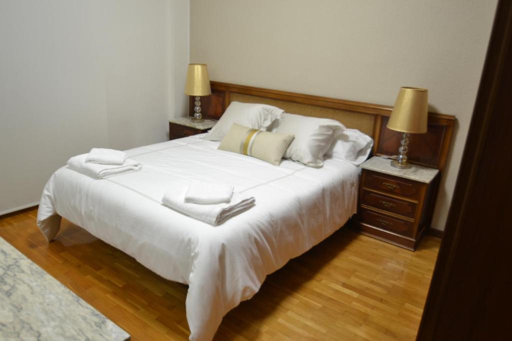 - une chambre avec un grand lit blanc et 2 tables de chevet dans l'établissement JV40 TURISMO, à Logroño