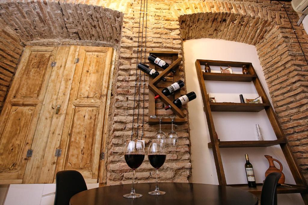 une table avec deux verres de vin sur un mur dans l'établissement Chrono Room, à Tbilissi