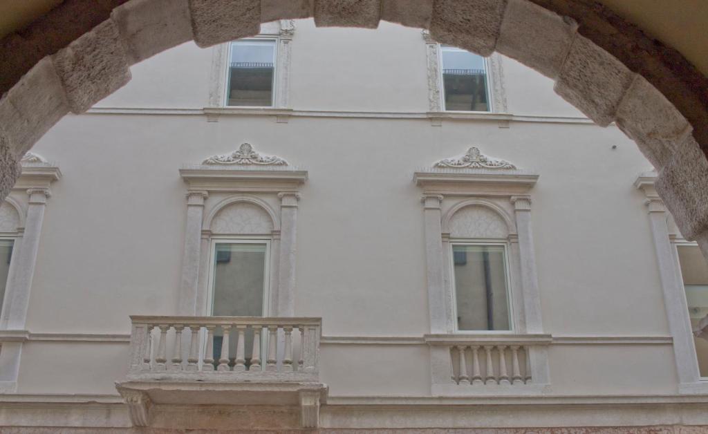 Edificio blanco con ventanas y balcón en Casa Bacca apartments, en Trento