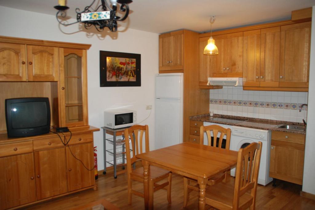 cocina con mesa de madera y comedor pequeño en APARTAMENTOS LÁZARO-Calle Iglesia 8 - 1º C en Escarrilla