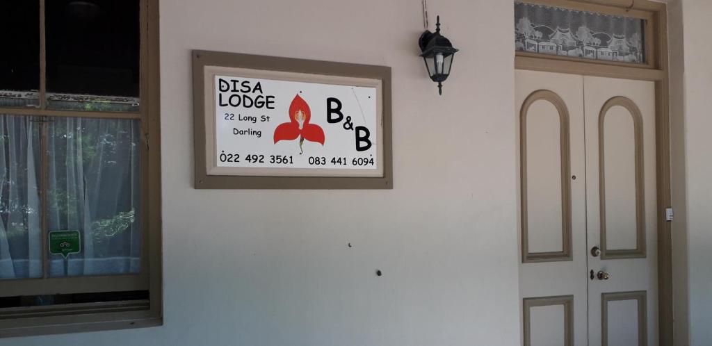 um sinal numa parede ao lado de uma porta em Disa Lodge em Darling