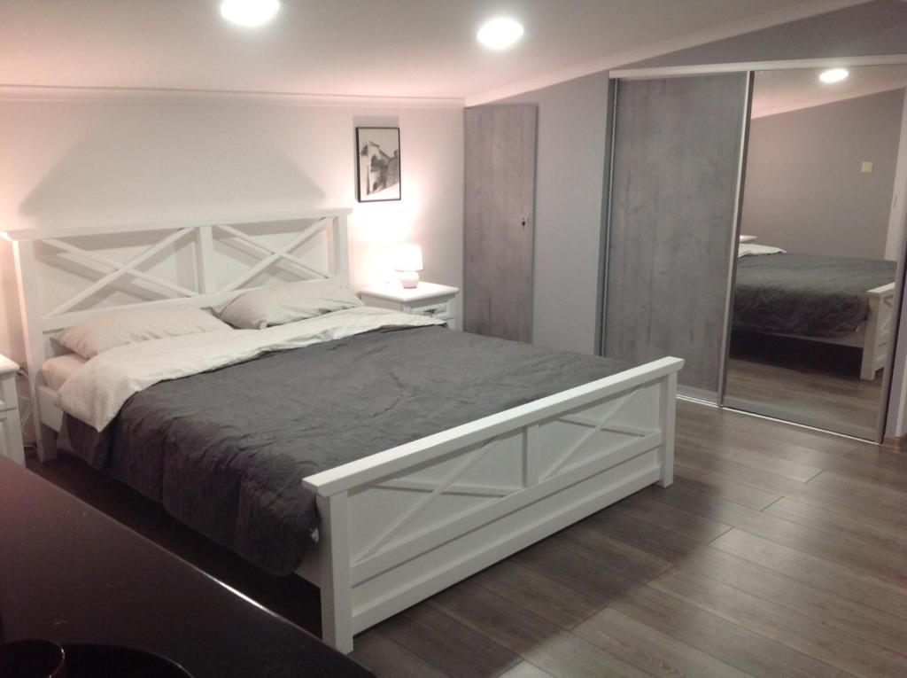 ein Schlafzimmer mit einem großen weißen Bett und einem Spiegel in der Unterkunft Апартаменты в Старом городе in Kamjanez-Podilskyj