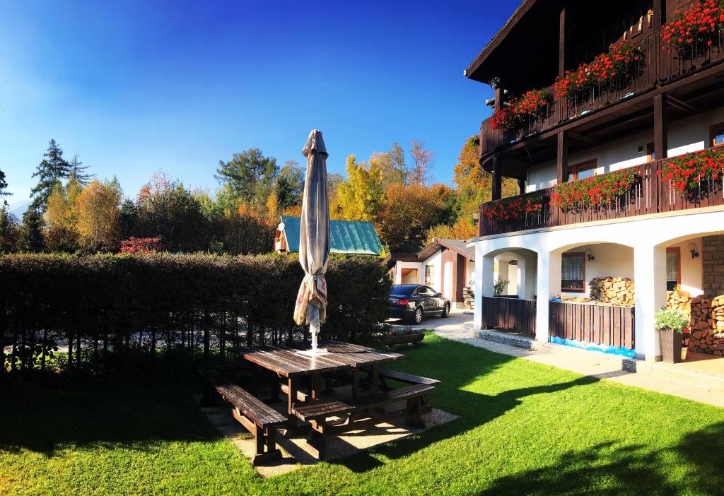 un parasol assis sur une table dans la cour d'une maison dans l'établissement Penzion Pažický, à Stará Lesná