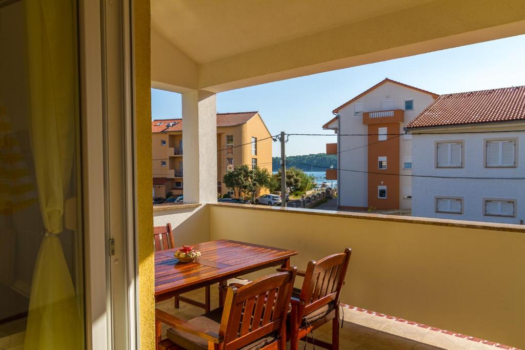 balcón con mesa, sillas y vistas en Apartments & Room Španjol, en Rab