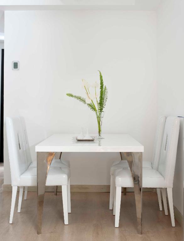 a white dining table with white chairs and a vase with flowers at Barceló Cairo Pyramids in Cairo
