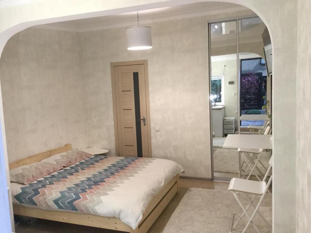 a bedroom with a bed and a table and a mirror at Дворик на Жуковского in Odesa