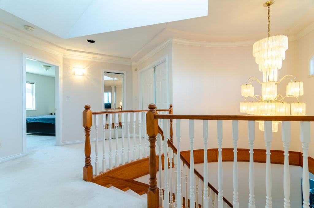 una escalera en una casa con una lámpara de araña en 3 Private, spacious, bright rooms in a Gorgeous house, en New Westminster