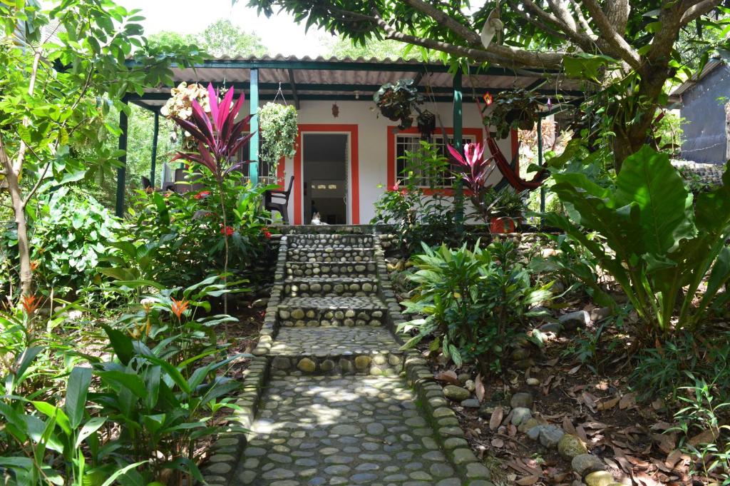 einen Garten mit einem Weg, der zu einem Haus führt in der Unterkunft Casa Oasis de colibri in El Zaino