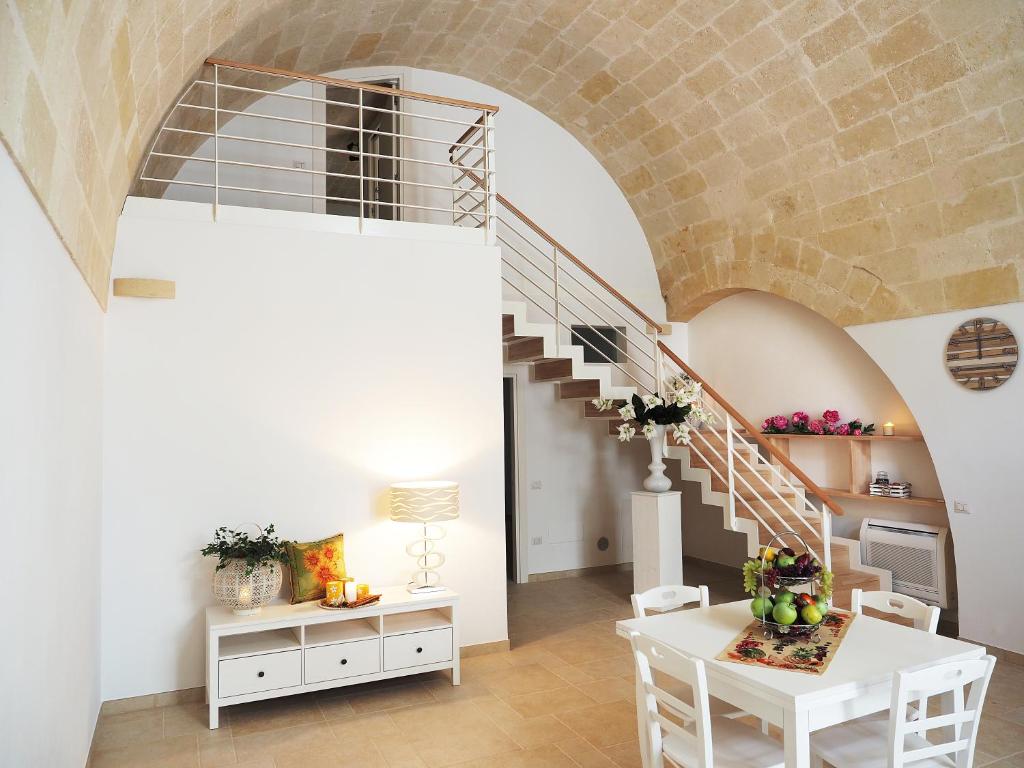 a living room with a staircase and a white table at L'ALBERO DELLA VITA in Matera