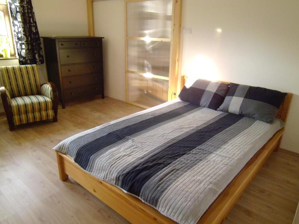 ミシュコルツにあるAulich Apartmanのベッドルーム1室(ドレッサー付きベッド1台、椅子付)