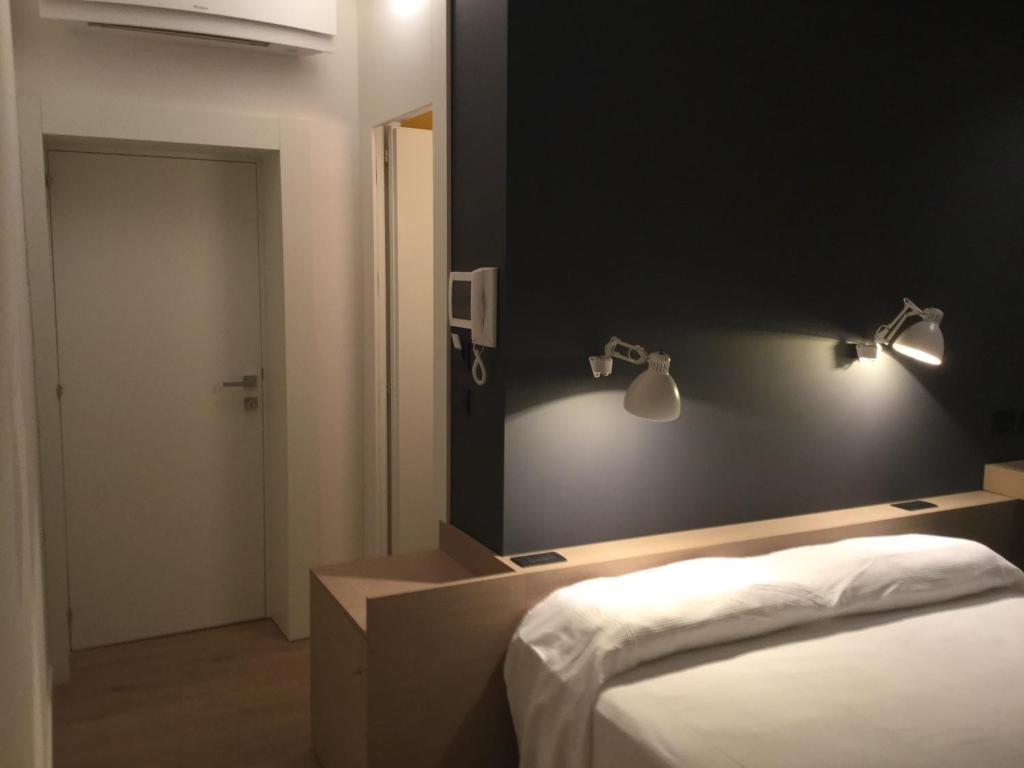 1 dormitorio con 1 cama y luces en la pared en Acquapazza Restaurant & Room, en San Benedetto del Tronto