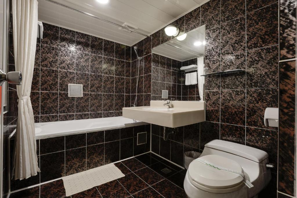 a bathroom with a toilet and a sink at Kaja Hotel in Kaohsiung