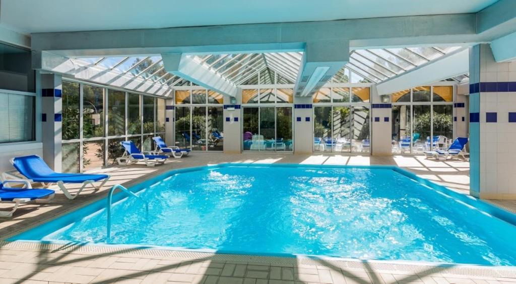- une piscine dans un bâtiment doté d'un plafond en verre dans l'établissement ibis Sète Balaruc les Bains Bien-être et Spa, à Balaruc-les-Bains