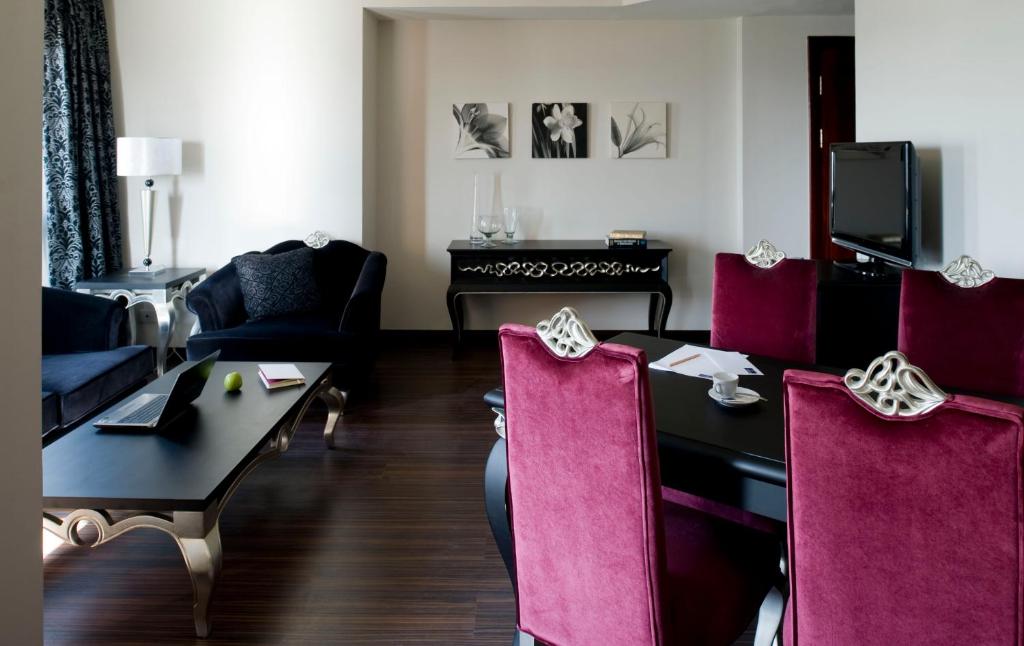 a living room with a table and pink chairs at Barceló Cairo Pyramids in Cairo