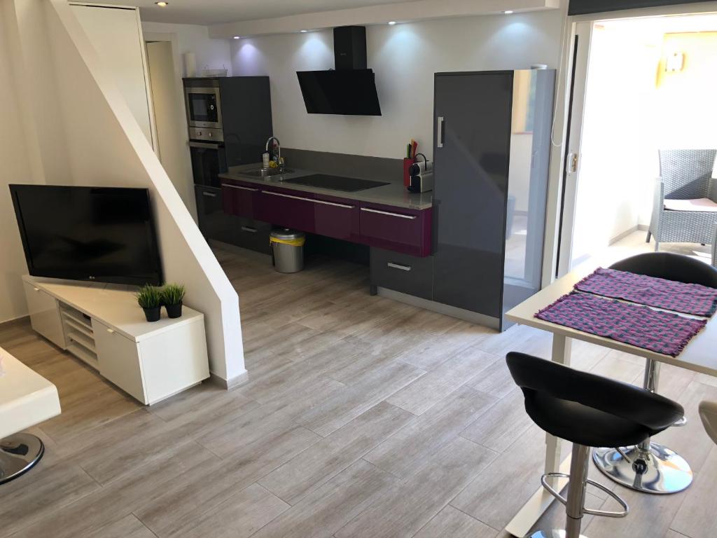a living room with a tv and a kitchen at Buenavista Apartment in Sitges