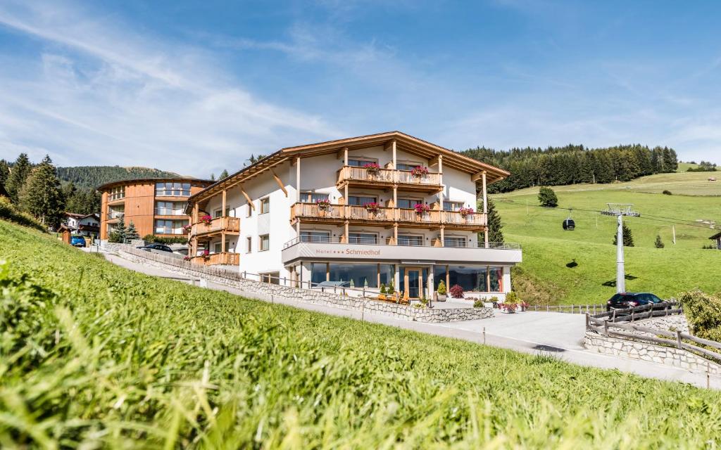 a large building on the side of a hill at Hotel Schmiedhof in Maranza