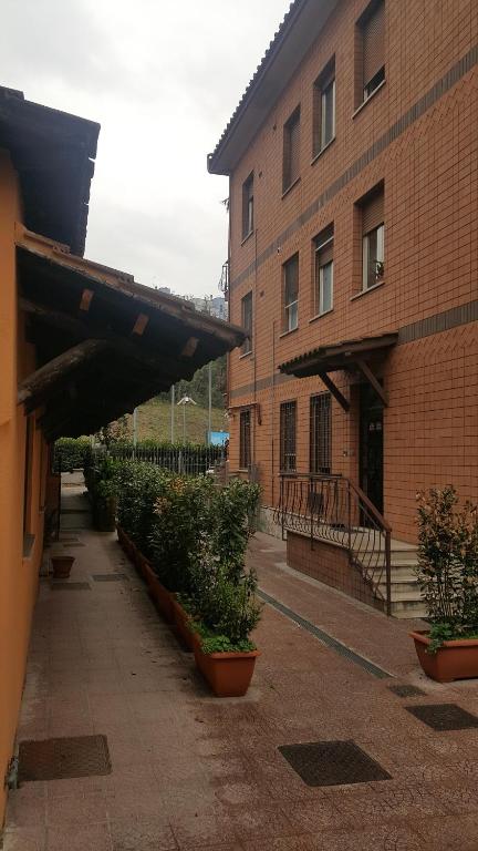 un bâtiment en briques avec des plantes en pot à côté d'un bâtiment dans l'établissement LA PALAZZINA, à Rome
