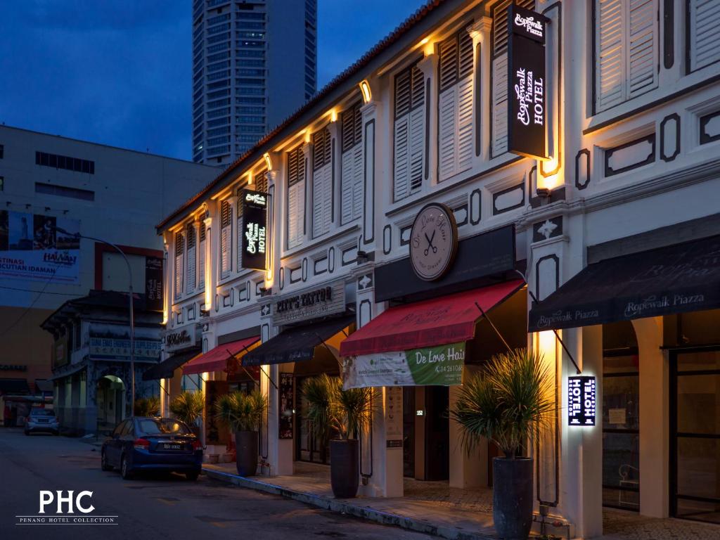 a building with a clock on the side of a street at Ropewalk Piazza Hotel Managed by The Ascott Limited in George Town