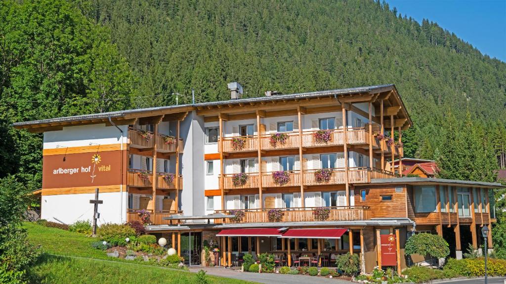 a large building with balconies on a mountain at Arlbergerhof Vital in Weissensee