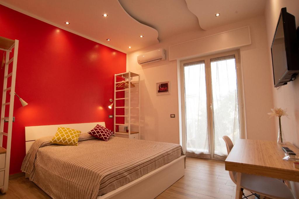拿坡里的住宿－Vanvitelli Domus，一间卧室设有红色的墙壁和一张带黄色枕头的床