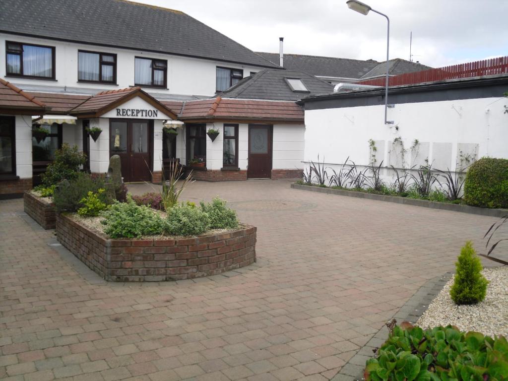 a brick courtyard in front of a white building at The Horse and Hound Hotel in Ballynabola