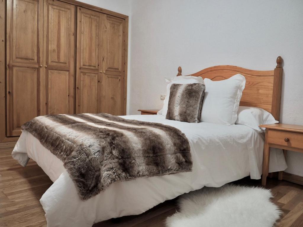 a bedroom with a bed with a blanket and pillows at Vora Riu in Esterri d'Àneu