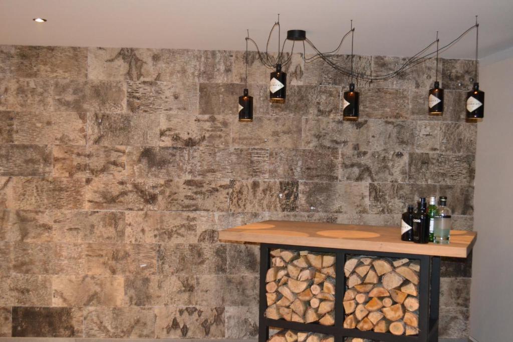 a stone wall with a table and some lights at Vue d'en Haut in Durbuy