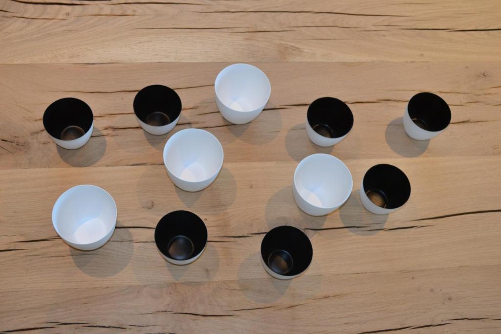 a group of white cups on a wooden table at Vue d'en Haut in Durbuy