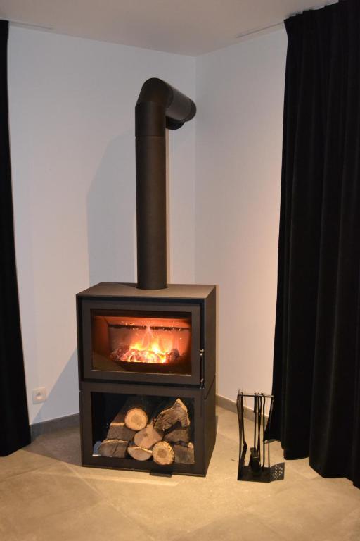a black stove with logs in a room at Vue d'en Haut in Durbuy