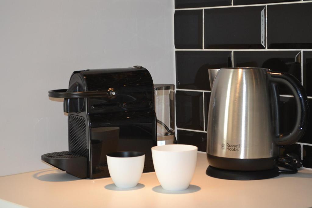 a coffee maker and two cups on a counter at Vue d'en Haut in Durbuy