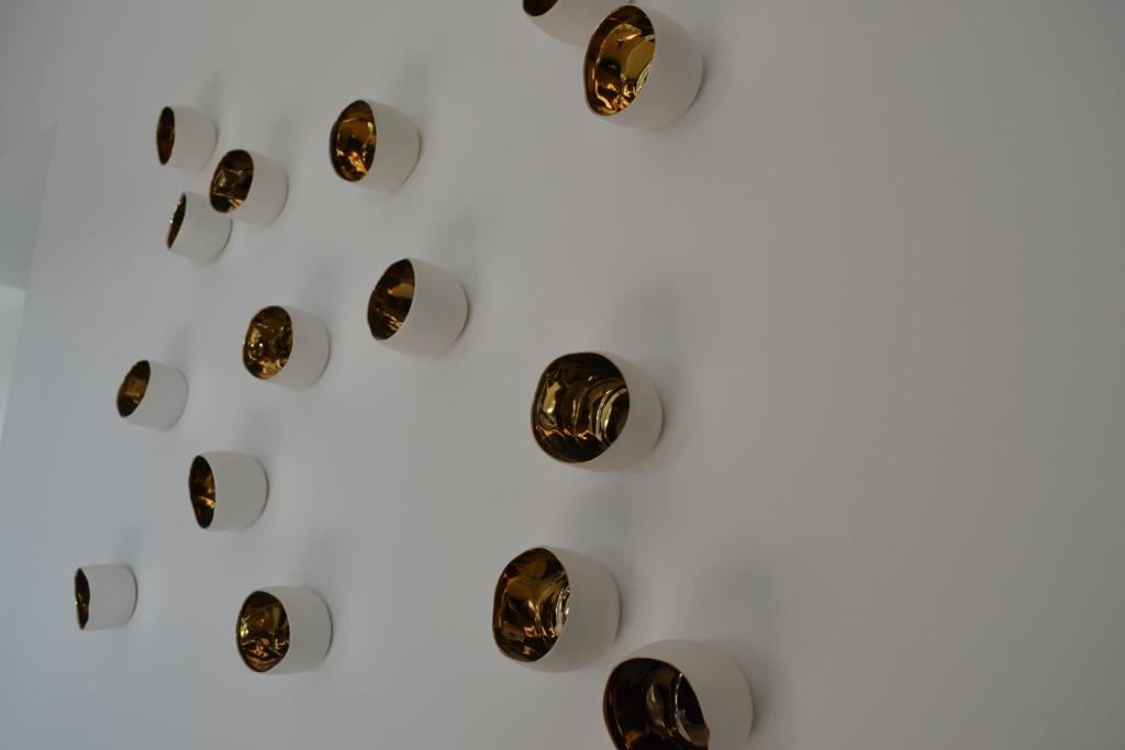 a group of gold discs on a white background at Vue d'en Haut in Durbuy