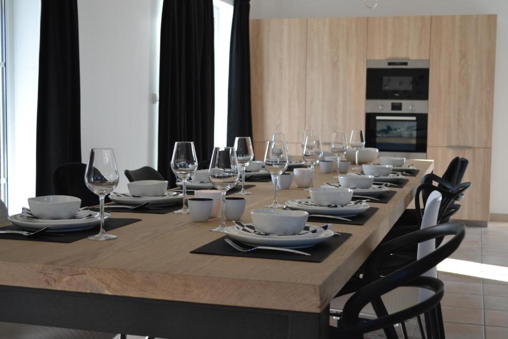a long table with wine glasses and plates on it at Vue d'en Haut in Durbuy