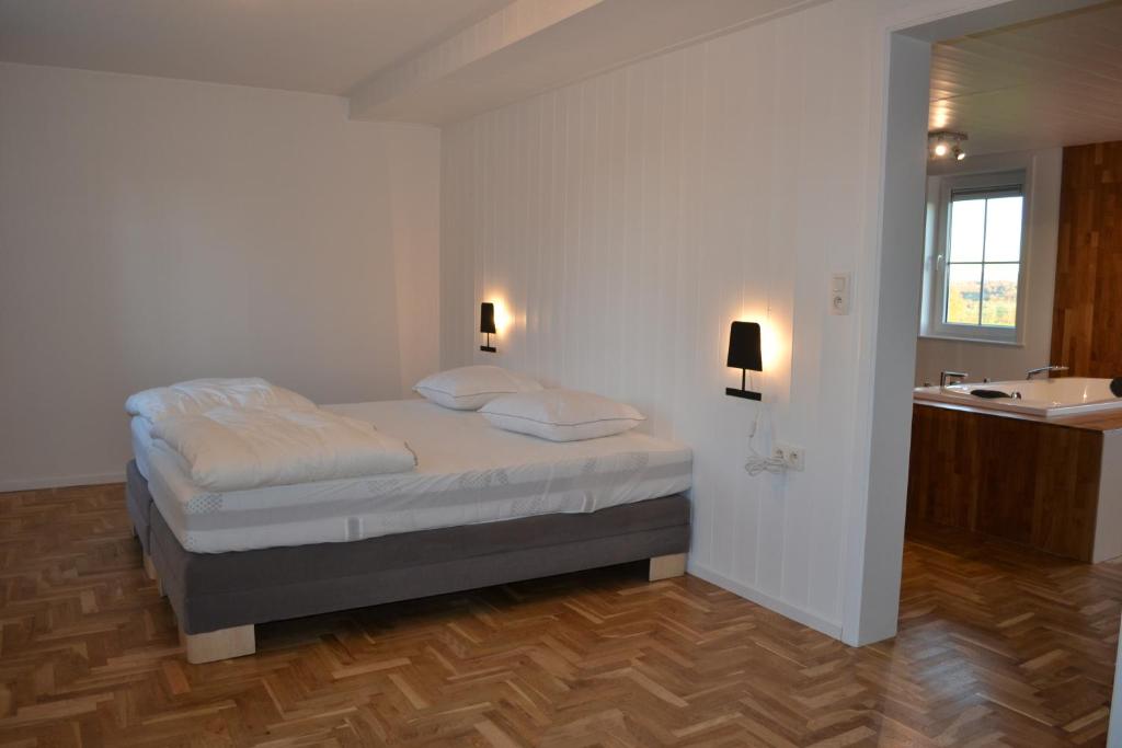 a bedroom with a bed and a bathroom with a sink at Vue d'en Haut in Durbuy