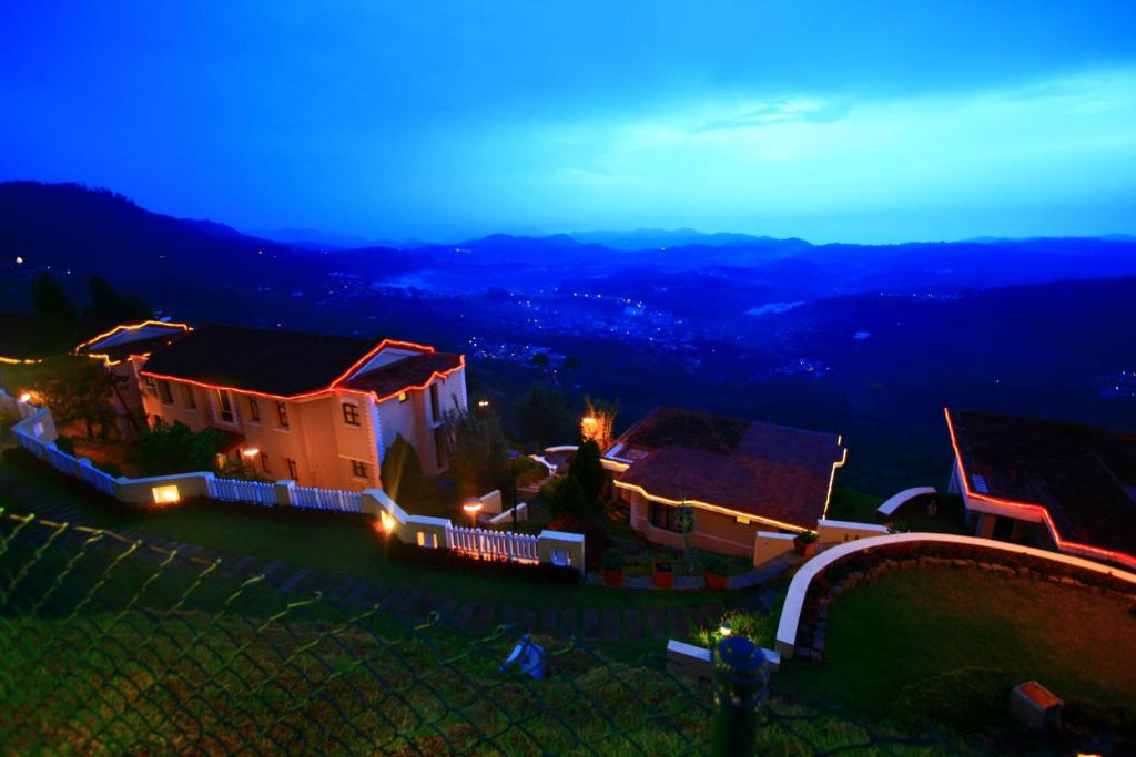 uma vista para uma casa à noite com luzes em Mountain Retreat - A Hill Country Resort em Ooty