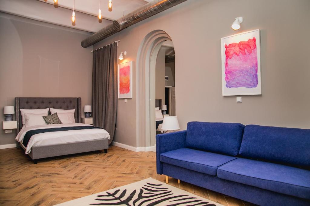 1 dormitorio con 1 cama y 1 sofá azul en W1 Katowice en Katowice