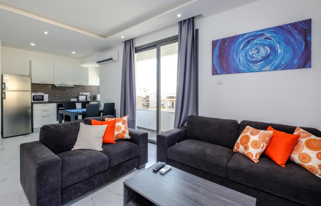 a living room with two couches and a kitchen at Lazuli Seaview Apartments 2Bdr in Larnaca