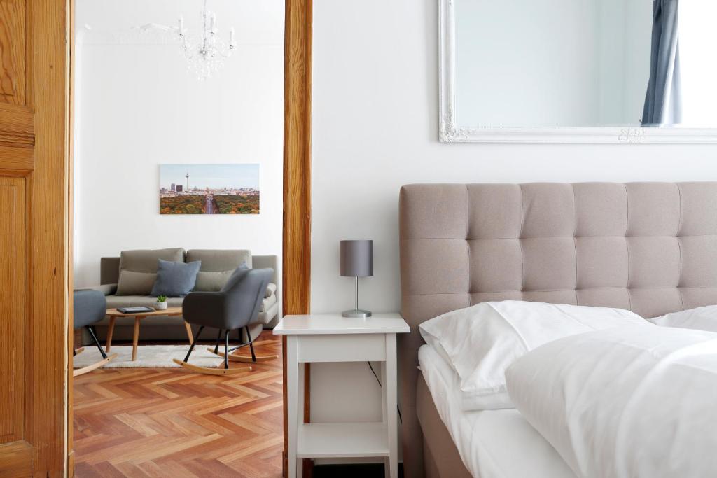 ein Schlafzimmer mit einem Bett, einem Sofa und einem Tisch in der Unterkunft Apartment KATZBACH - Cozy Family & Business Flair welcomes you - Rockchair Apartments in Berlin