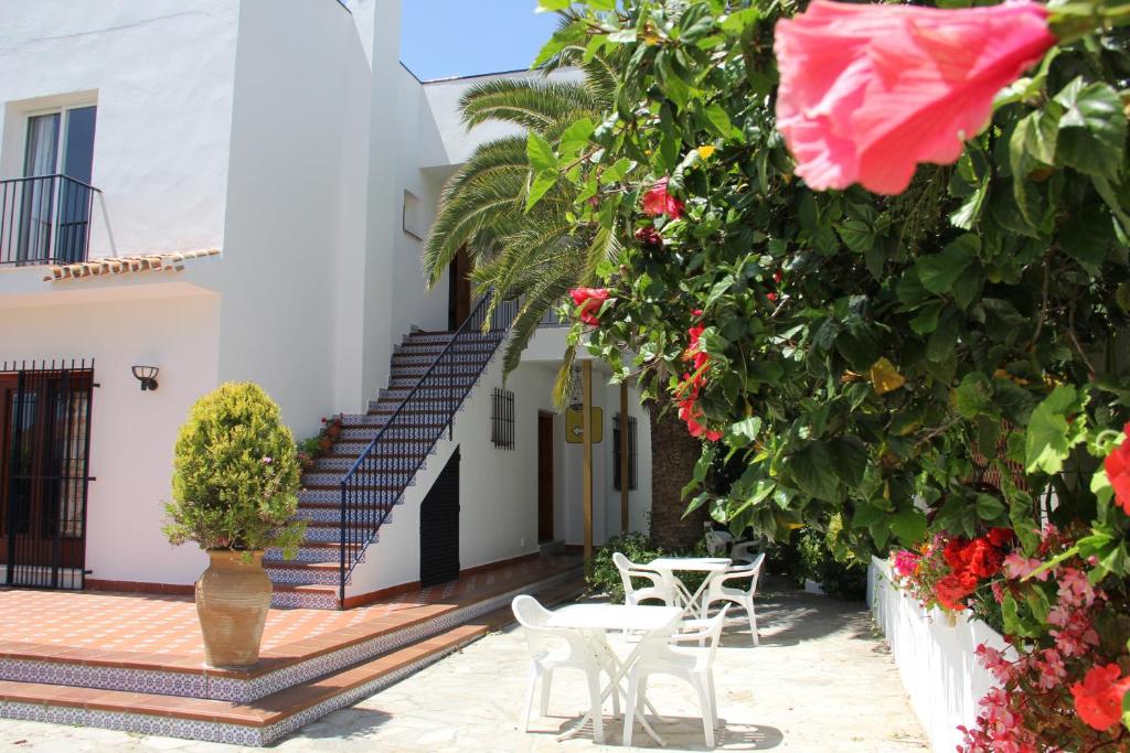 a courtyard of a building with chairs and flowers at Hotel California in Nerja