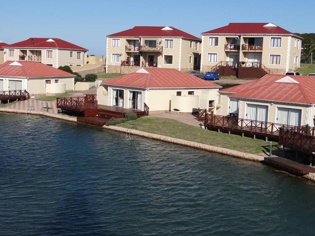 a row of houses next to a body of water at Waterside Living MS22 in Jeffreys Bay