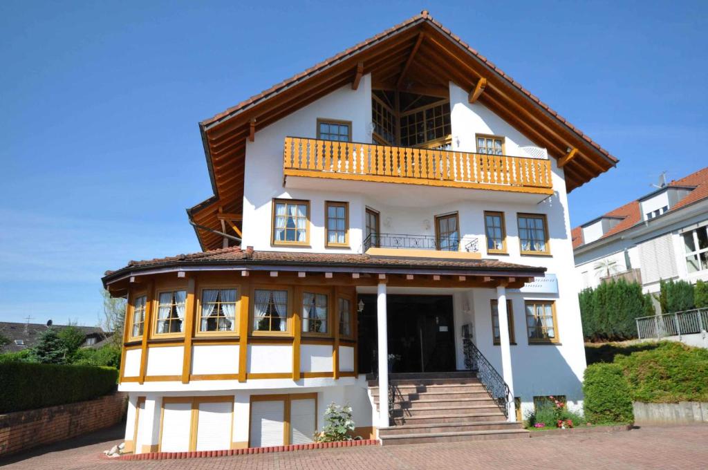 a white building with a balcony on top at Hotel-Pension-Jasmin in Rheinfelden