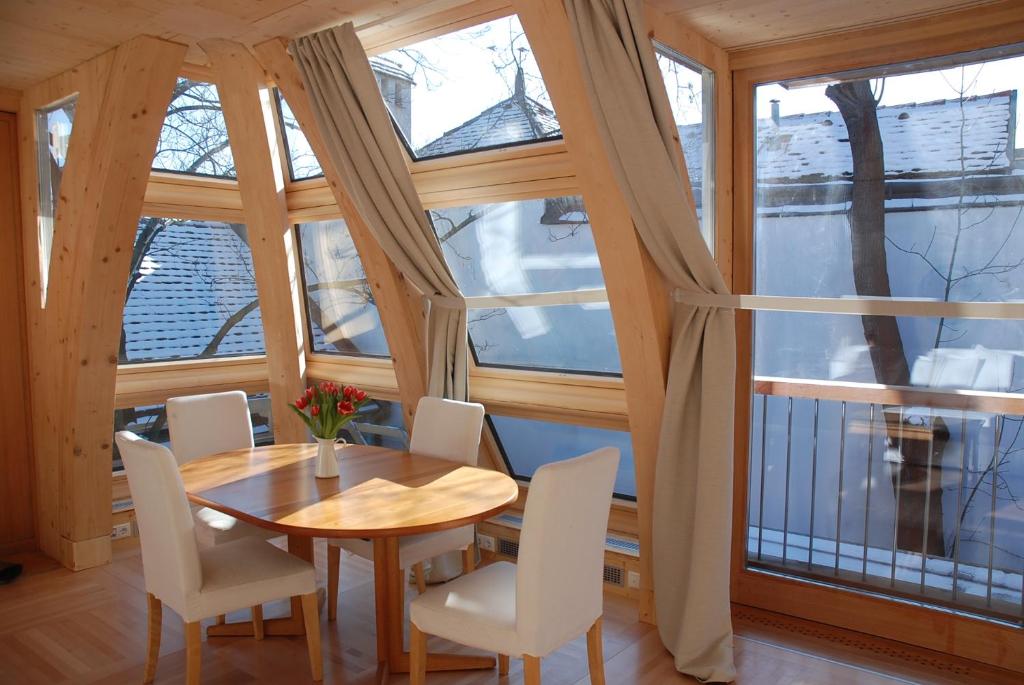 a dining room with a table and chairs and windows at Sunny Apartments Vienna in Vienna