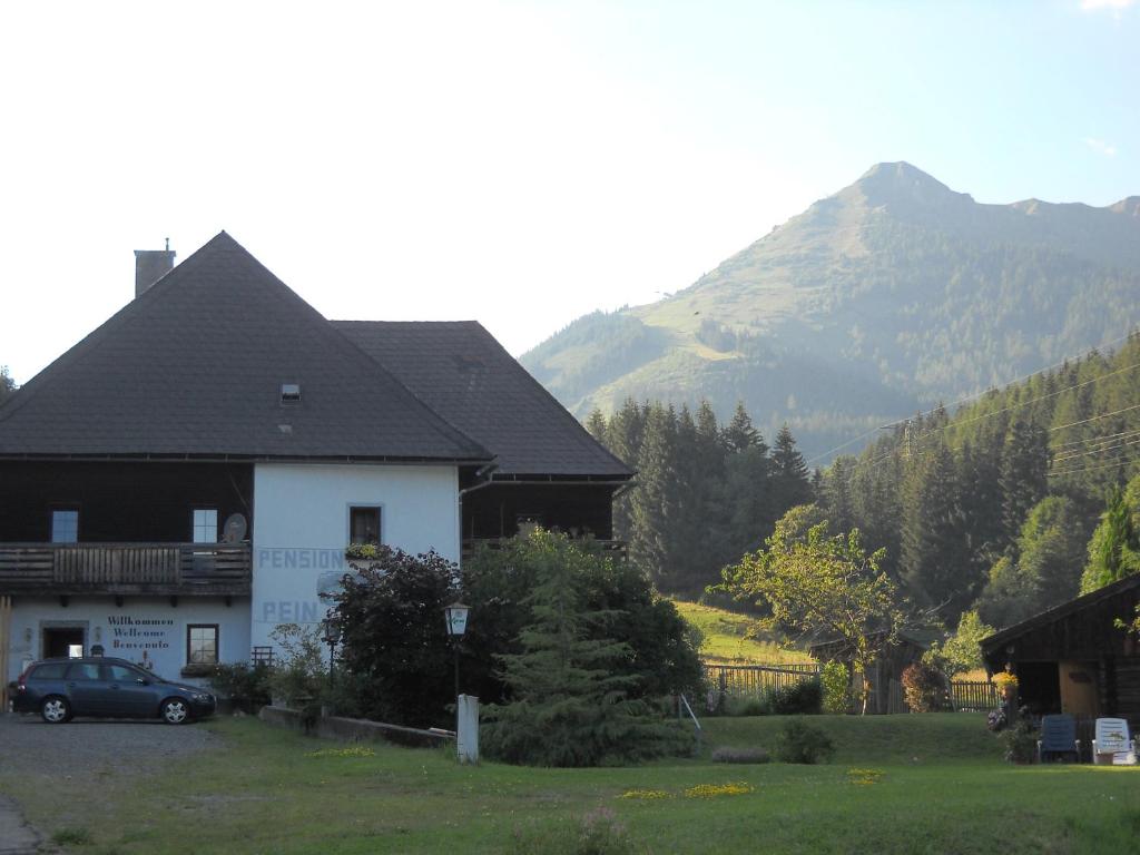 una casa con un coche aparcado frente a una montaña en Ferienwohnungen Pein, en Vordernberg