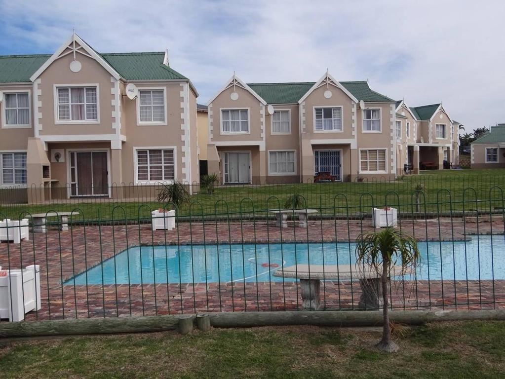 a large house with a swimming pool in front of it at Waterside Living CL07 in Jeffreys Bay